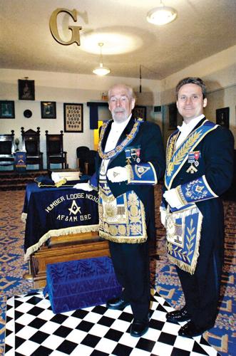 Grand Master Raymond S. J. Daniels and District Deputy Grand Master Andrew J. Turk of the Humber Masonic Lodge stand by the altar adorned with a “Volume of Sacred Law” in the Weston Temple.
